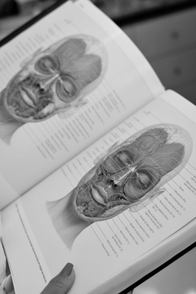 Black and white image of a medical anatomy book showing human facial structure diagrams.